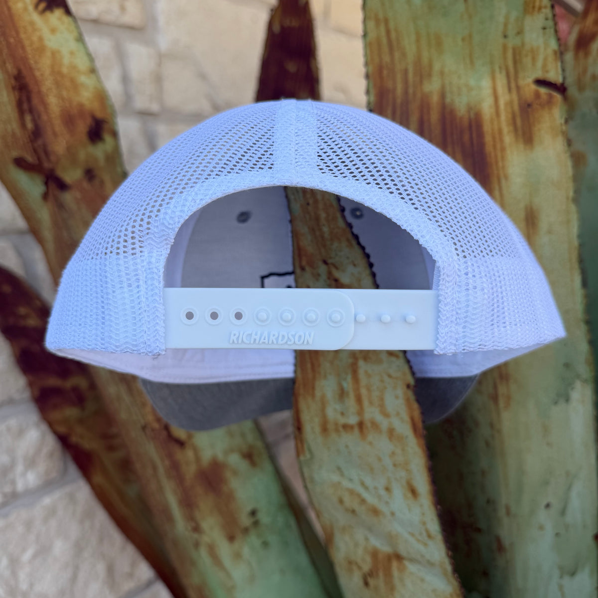 A white Richardson trucker-style cap with a mesh back and adjustable snap strap