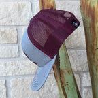 A two-tone trucker cap with a maroon mesh back and a light gray fabric brim, 