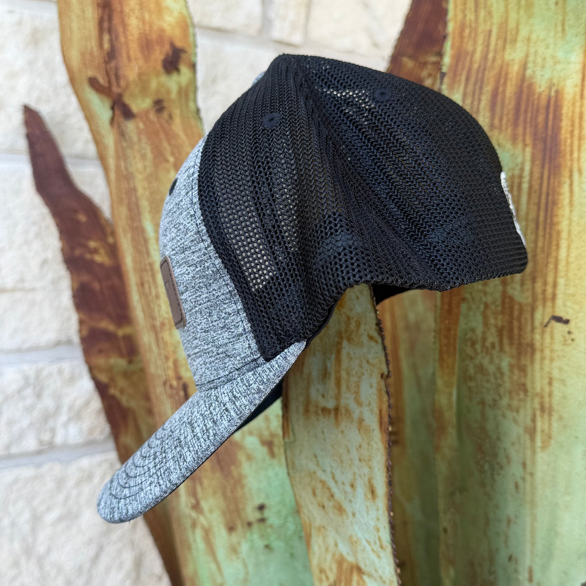 A two-tone trucker cap with a black mesh back and a heather gray front panel and brim, 