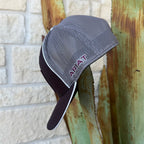 A gray and dark burgundy trucker-style cap with a mesh back and a dark visor, The word 'ARIAT' is embroidered in burgundy on the side 
