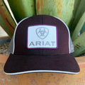 A dark burgundy and white ARIAT trucker hat with a white front patch featuring the brand logo