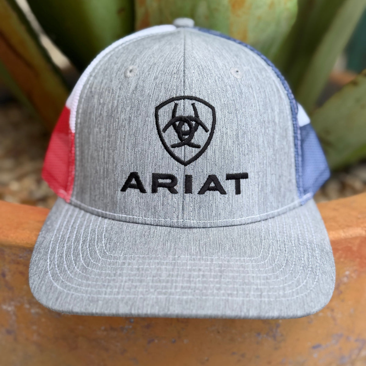 A heather gray trucker-style cap with black embroidered Ariat logo and text on the front
