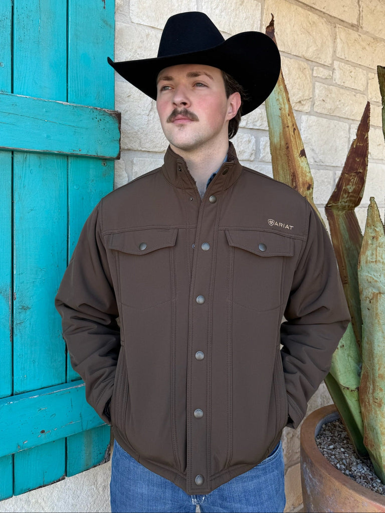 Men’s Ariat Softshell Sherpa Snap Jacket in dark chocolate, built with wind-resistant fabric and sherpa lining for warmth, featuring snap-front closure and secure zip hand pockets – 10062618. Available at Blair’s Western Wear, Marble Falls, TX.