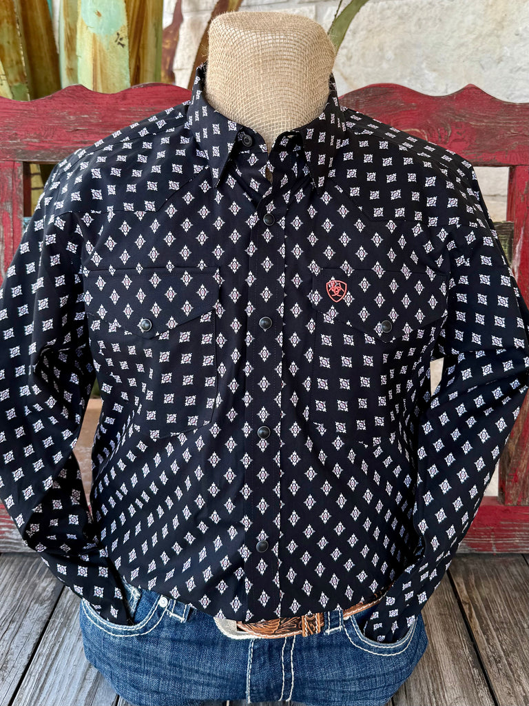 Men’s Ariat Western long-sleeve print shirt in black with red and white geometric pattern, featuring snap-front closure and dual chest pockets – 10065785. Available at Blair’s Western Wear, Marble Falls, TX.
