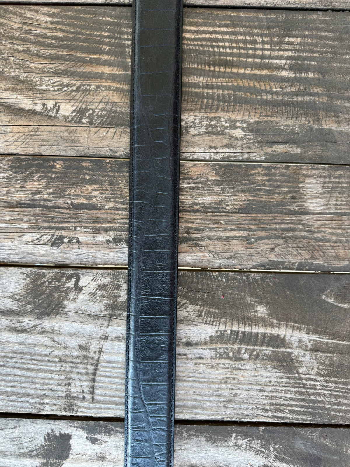Black leather with deep caiman print scaling and a clean tapered tip — bold exotic texture with a sleek, all-black finish. A statement belt that pairs with virtually anything in your western wardrobe.