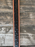 Black ostrich print leather with tan leather trim edges and cream contrast stitching, finished with a large engraved silver western buckle — an exotic, eye-catching belt with refined western character. Find it at Blair's Western Wear in Marble Falls, TX or online at blairswesternwear.com.
