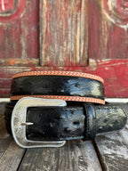 Black ostrich print leather with tan leather trim edges and cream contrast stitching, finished with a large engraved silver western buckle — an exotic, eye-catching belt with refined western character. Find it at Blair's Western Wear in Marble Falls, TX or online at blairswesternwear.com.