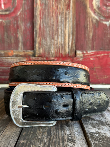 Black ostrich print leather with tan leather trim edges and cream contrast stitching, finished with a large engraved silver western buckle — an exotic, eye-catching belt with refined western character. Find it at Blair's Western Wear in Marble Falls, TX or online at blairswesternwear.com.