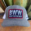 A heather gray and white trucker hat with a prominent rectangular patch on the front that reads 'BWW BLAIR'S WESTERN WEAR'. 