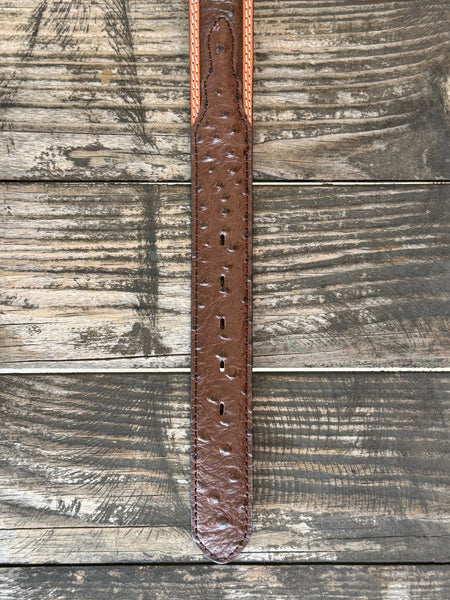 Dark chocolate ostrich print leather with a tan leather trim edge and cream contrast stitching, finished with an engraved silver western buckle — a refined, two-tone exotic belt with the kind of texture and detail that elevates any western outfit.