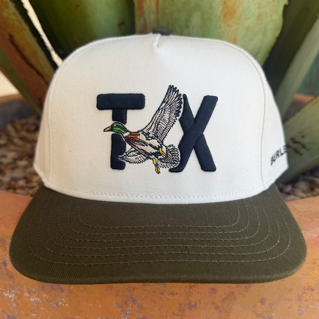 A white and olive green trucker-style cap featuring an embroidered 'TX' with a flying mallard duck in the center. 