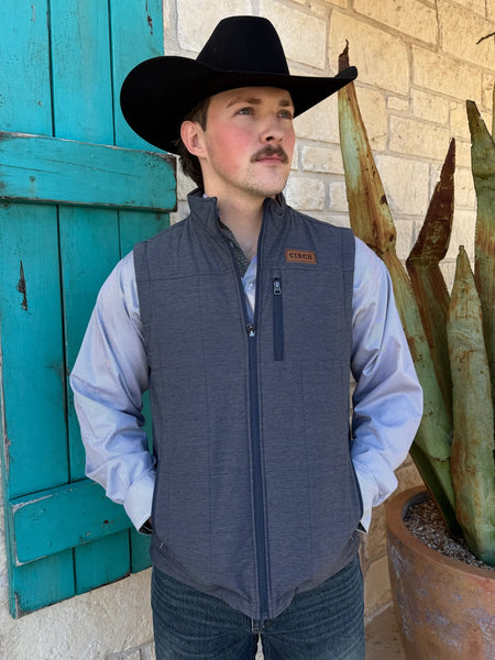 Men’s Cinch reversible quilted vest in navy/gray, featuring lightweight insulation and zip hand pockets, with full zip front and leather logo patch – MWV1926001. Available at Blair’s Western Wear, Marble Falls, TX.
