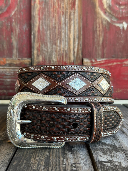 Dark chocolate basketweave tooled leather with diamond-shaped engraved silver conchos, silver dome studs along the edges, cream contrast stitching, and a large engraved silver western buckle — a premium, heavily detailed belt built for the man who doesn't do anything halfway.