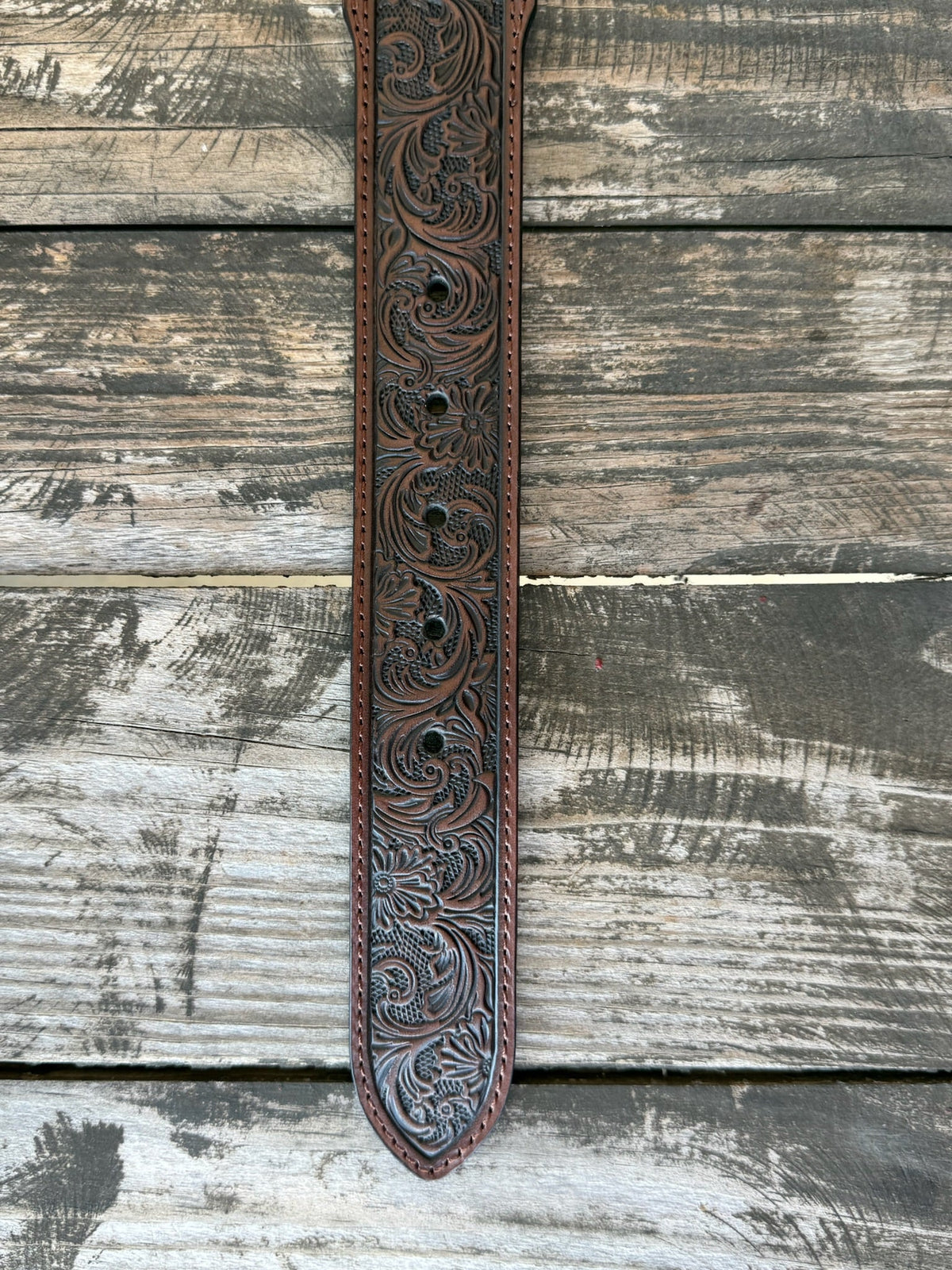 Dark chocolate leather with edge-to-edge floral scroll tooling and a large engraved silver western buckle — a timeless western belt with deep, handcrafted detail that speaks for itself. Clean lines, rich texture, and the kind of quality that gets better with every wear.