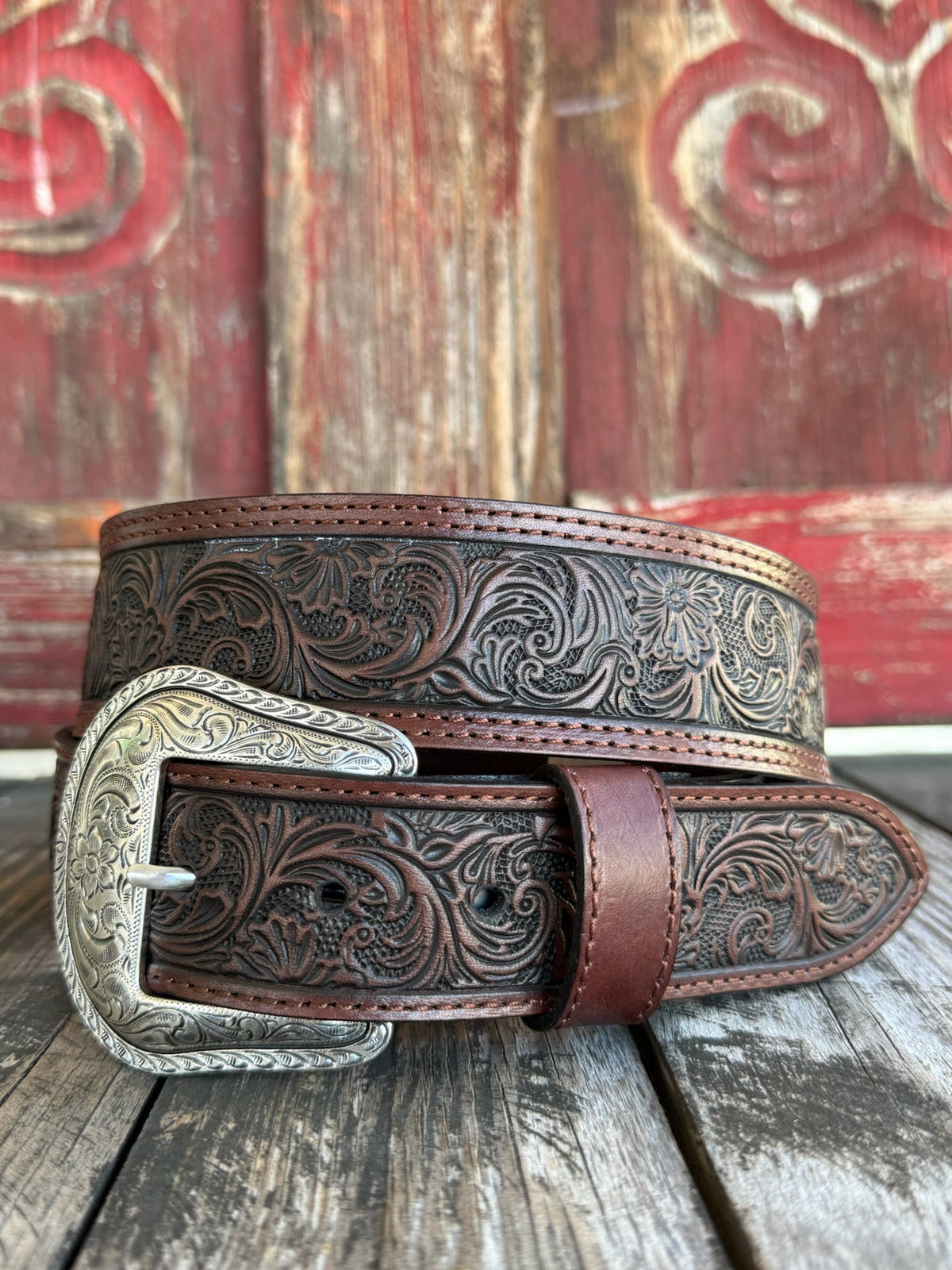 Dark chocolate leather with edge-to-edge floral scroll tooling and a large engraved silver western buckle — a timeless western belt with deep, handcrafted detail that speaks for itself. Clean lines, rich texture, and the kind of quality that gets better with every wear.