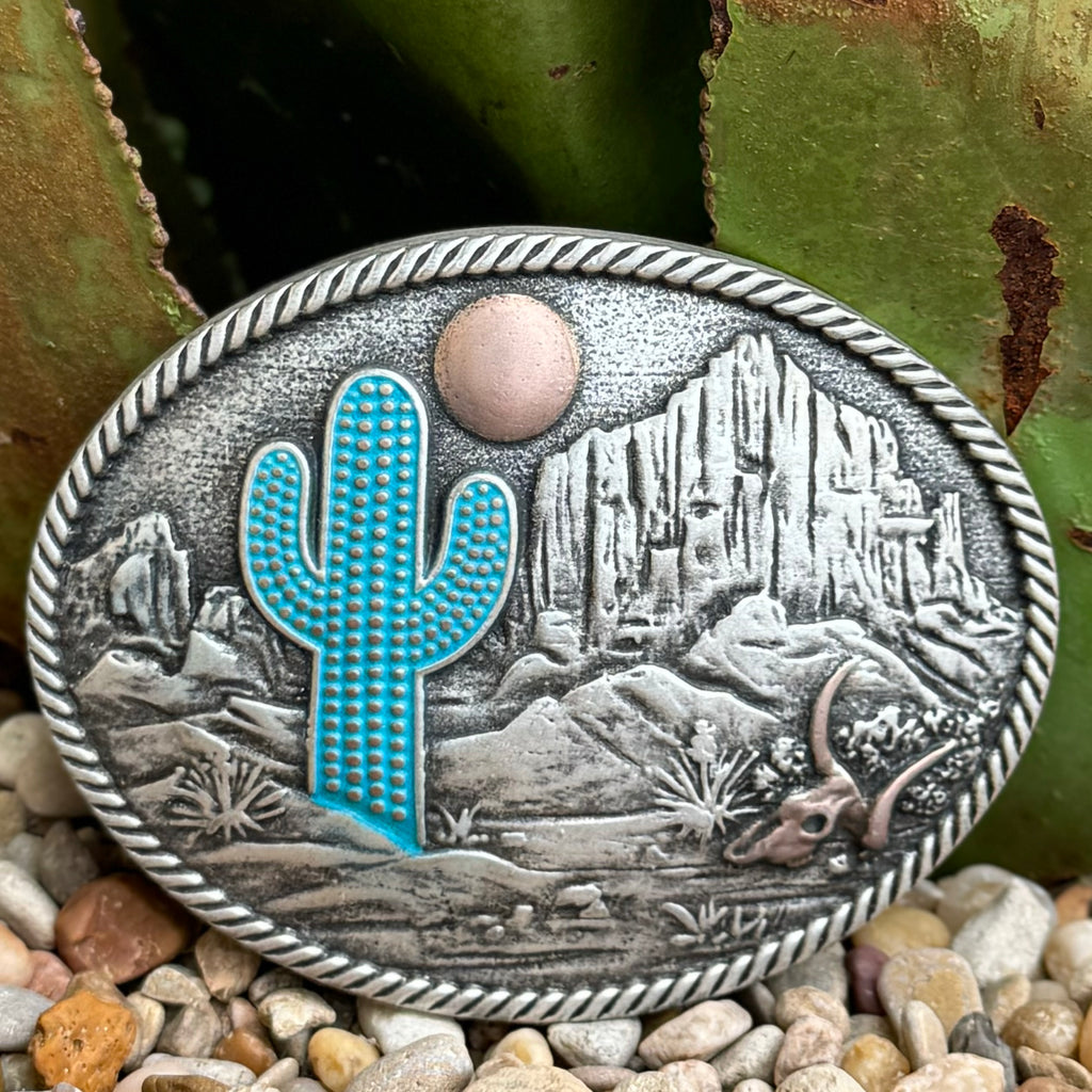 Men’s Montana Silversmiths Western Buckle in Silver, bold turquoise cactus centerpiece, with rose gold-tone sun detail and raised mountain and skull accents - A825. Available at Blair's Western Wear, Marble Falls, TX.