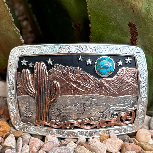 Men’s Montana Silversmiths Western Buckle in Desert Moon, features a copper cactus and mountain scene, with a turquoise-accented moon and silver starry sky - 42110. Available at Blair's Western Wear, Marble Falls, TX.