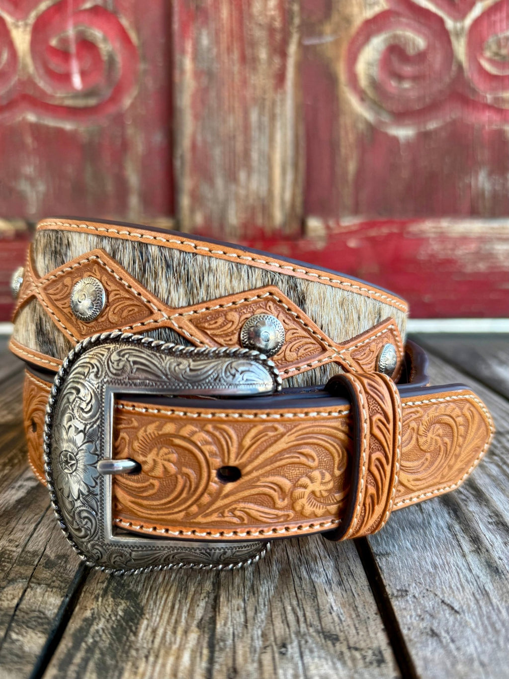 Men’s Nocona Western belt in tan/brown, crafted from genuine leather with hair-on-hide inlay that adds natural texture and a one-of-a-kind pattern to each belt, with diamond-shaped concho accents delivering classic Western detailing - N210010608. Available at Blair's Western Wear, Marble Falls, TX.