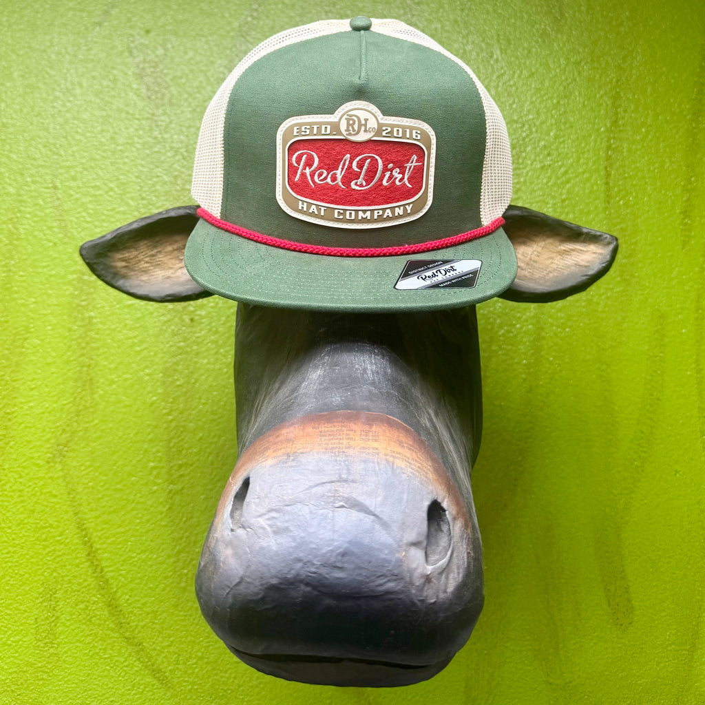 Men’s Red Dirt Hat Co. mesh logo patch cap in green, red, and natural, featuring an embroidered logo patch, breathable mesh back, and red rope trim – RDHC520. Available at Blair’s Western Wear, Marble Falls, TX.