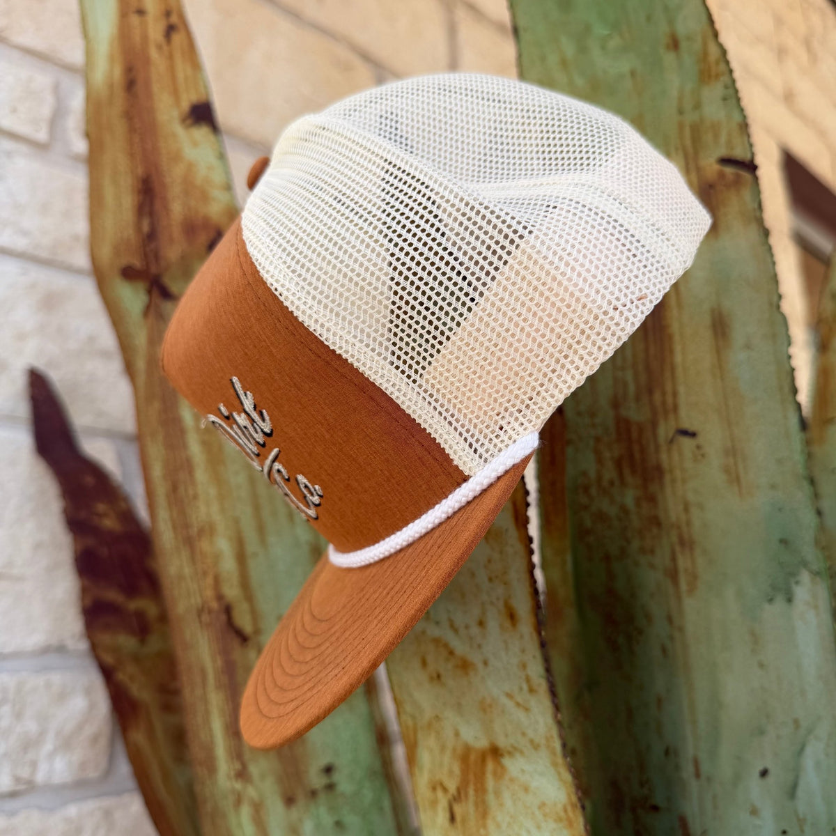 A brown and off-white trucker hat with a mesh back,