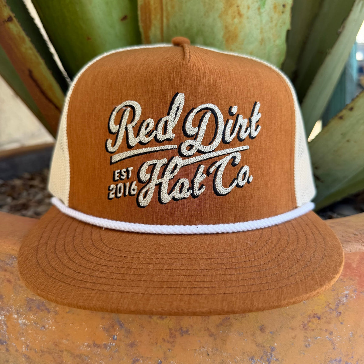 A brown and cream trucker hat with 'Red Dirt Hat Co. EST 2016' embroidered on the front