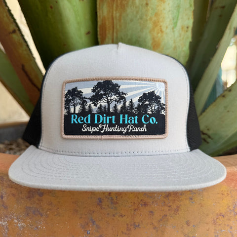 A light gray and black trucker hat with a front patch reading 'Red Dirt Hat Co. Snipe Hunting Ranch' and a tree graphic