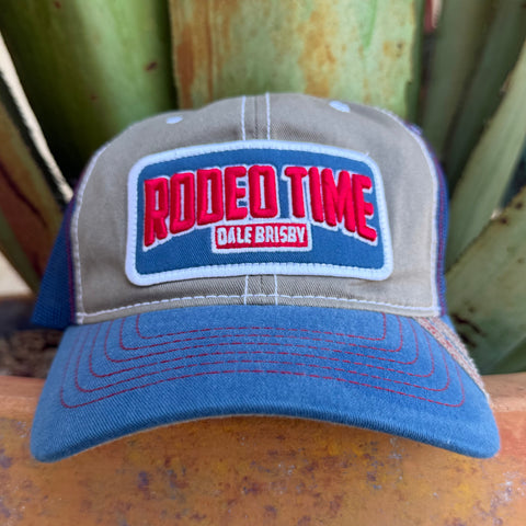 A trucker-style cap with a gray front panel, blue brim and mesh side panels, and a large front patch reading 'RODEO TIME' in red with 'DALE BRISBY' below it
