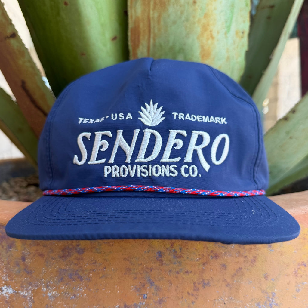 A navy blue cap with 'SENDERO PROVISIONS CO.' embroidered in white on the front with a red & blue rope sitting on the brim 
