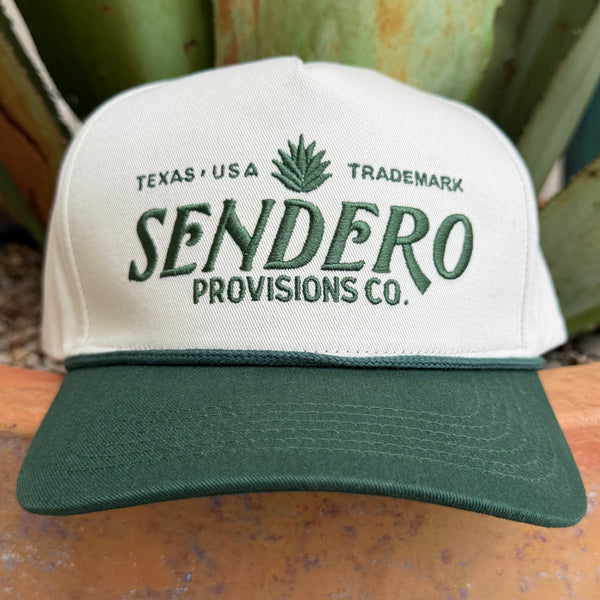 An off-white and dark green trucker-style cap with 'SENDERO PROVISIONS CO.' embroidered on the fron