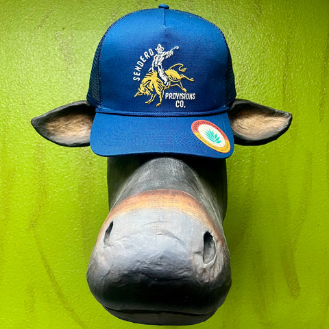 Men's Sendero Provisions Co. Bull Rider Cowboy Cap in deep blue with an embroidered gold bull rider design, breathable mesh backing, and adjustable snapback. Available at Blair's Western Wear, Marble Falls, TX.