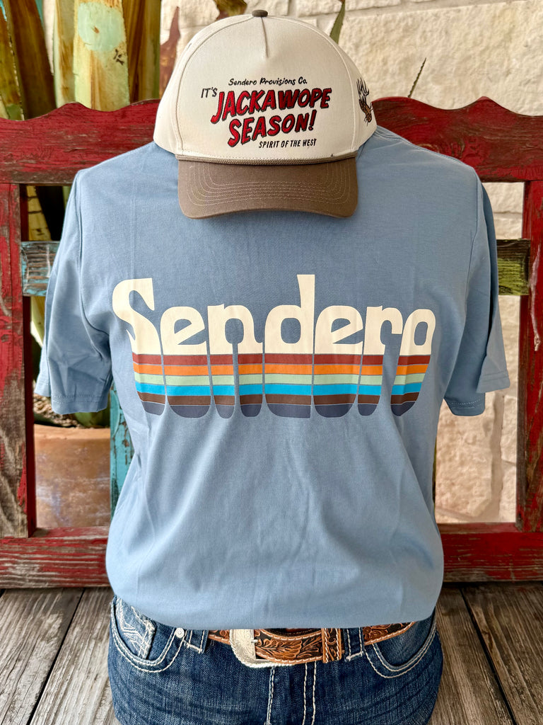 Men’s Sendero Provisions Co. graphic short sleeve t-shirt in light blue with multi-color retro stripe logo, made with a soft cotton blend, and featuring durable print that resists fading - SPCS125S28. Available at Blair's Western Wear, Marble Falls, TX.