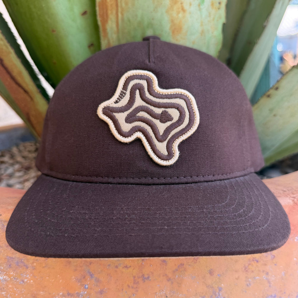 A dark brown cap with a topographic-style embroidered logo patch on the front