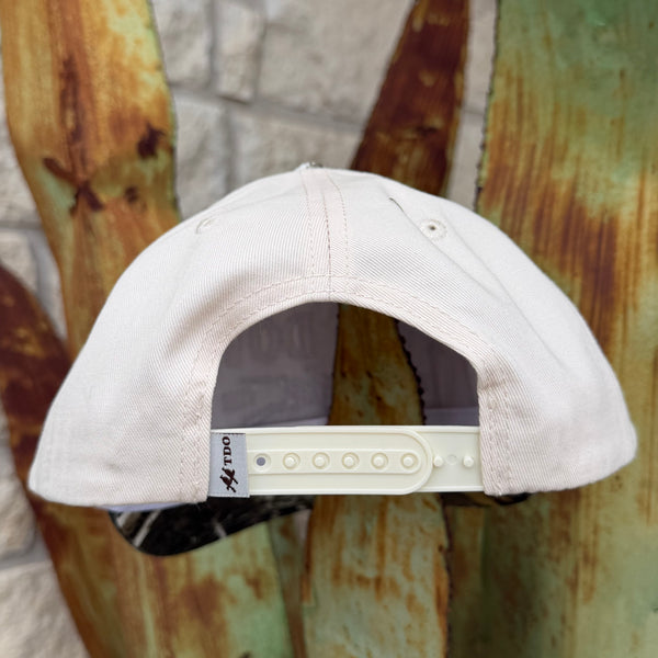 A light cream/off-white baseball cap shown from the back, featuring a white plastic snapback closure 