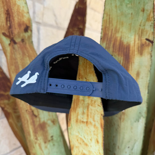 A navy blue cap with a white bird logo on the side, shown from the back 