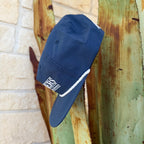 A navy blue cap with a white rope detail and a white embroidered logo reading 