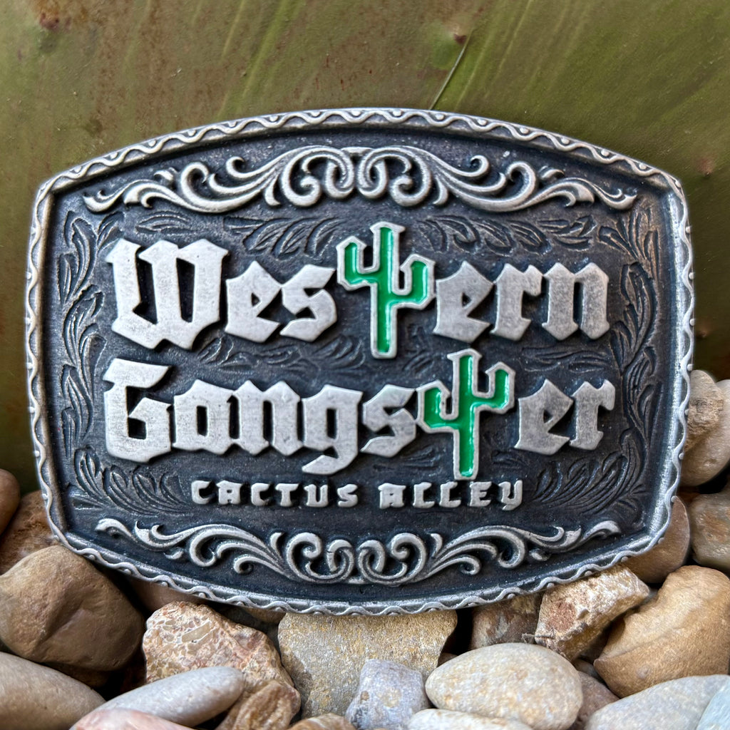 Montana Silversmiths Western silver Attitude buckle in antiqued silver, raised “Western Gangster” lettering with green cactus accents, with deep-etched scrollwork detailing - A1084CA. Available at Blair's Western Wear, Marble Falls, TX.