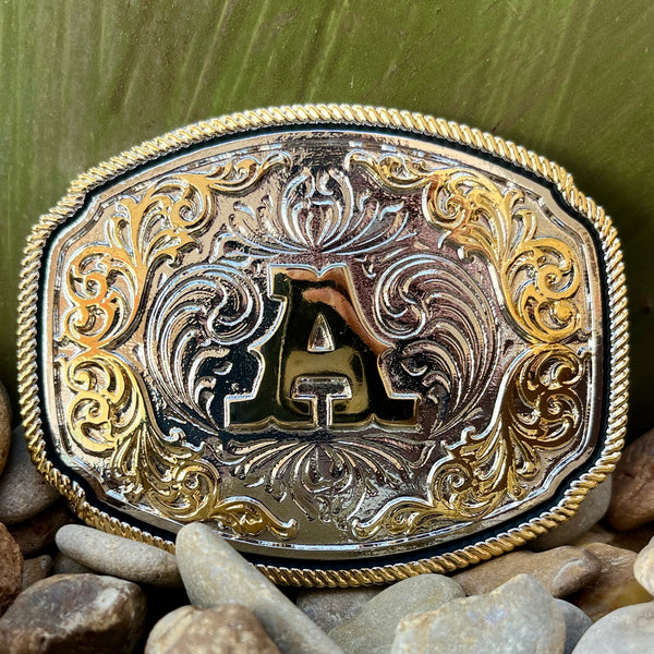 Montana Silversmiths Belt Buckle in Gold and Silver, traditional Western scroll design with twisted rope trim and central letter A - A1047A. Available at Blair's Western Wear, Marble Falls, TX.