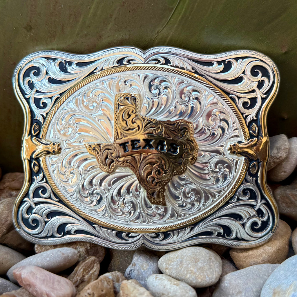 Montana Silversmiths belt buckle scalloped Texas buckle in silver and gold, hand-engraved bright silver finish with deep black antiqued accents, with sculpted gold-tone Texas state centerpiece featuring raised TEXAS lettering - 55610-610TX. Available at Blair's Western Wear, Marble Falls, TX.