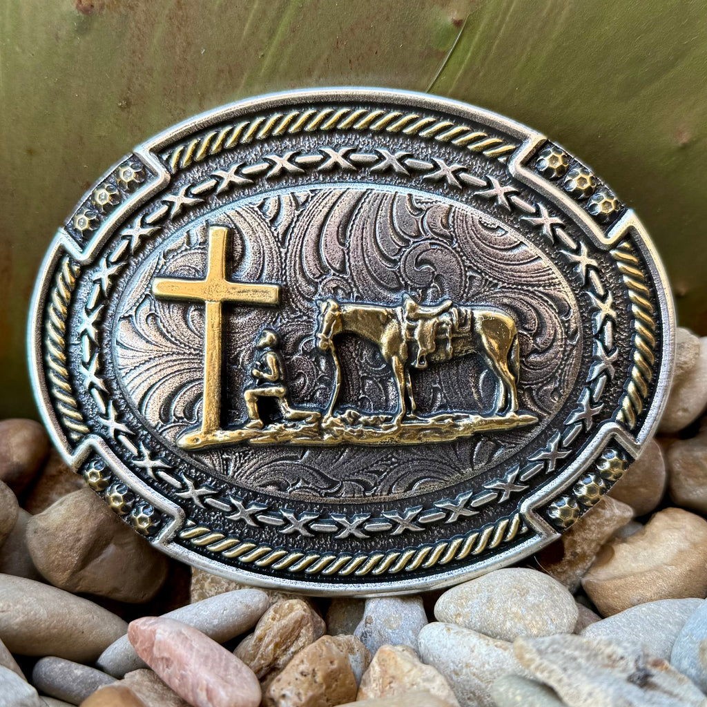 Montana Silversmiths belt buckle Cowboy Prayer buckle in silver and gold, detailed gold-tone cowboy prayer scene with kneeling rider and cross, with antiqued engraved Western scrollwork background - A1074P. Available at Blair's Western Wear, Marble Falls, TX.