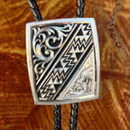 Montana Silversmiths Bolo Tie Silver Aztec in silver, engraved silver-tone pendant with bold Aztec-inspired geometric detailing, with black braided leather cord for durable all-day wear - BT6064. Available at Blair's Western Wear, Marble Falls, TX.