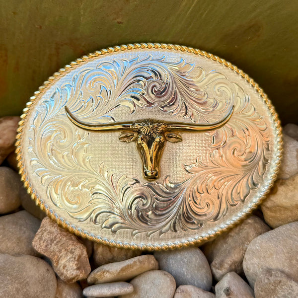 Montana Silversmiths oval silver/gold buckle with longhorn head in silver/gold finish, hand-engraved scrollwork, with a rope-edge trim - 1255-767M. Available at Blair's Western Wear, Marble Falls, TX.