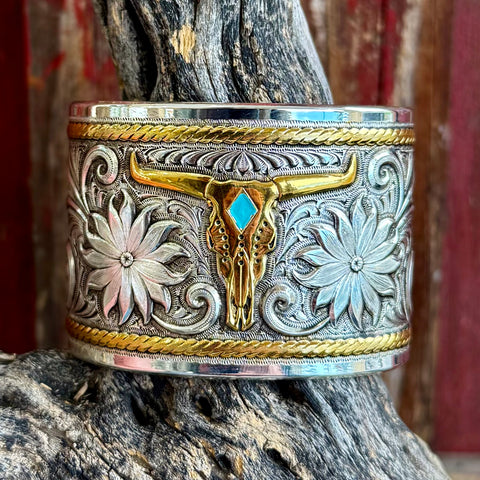 Montana Silversmiths cuff bracelet two-tone longhorn bangle in silver and gold, featuring a turquoise-accented longhorn center with engraved floral scrollwork – BC1626RTG. Available at Blair's Western Wear, Marble Falls, TX.