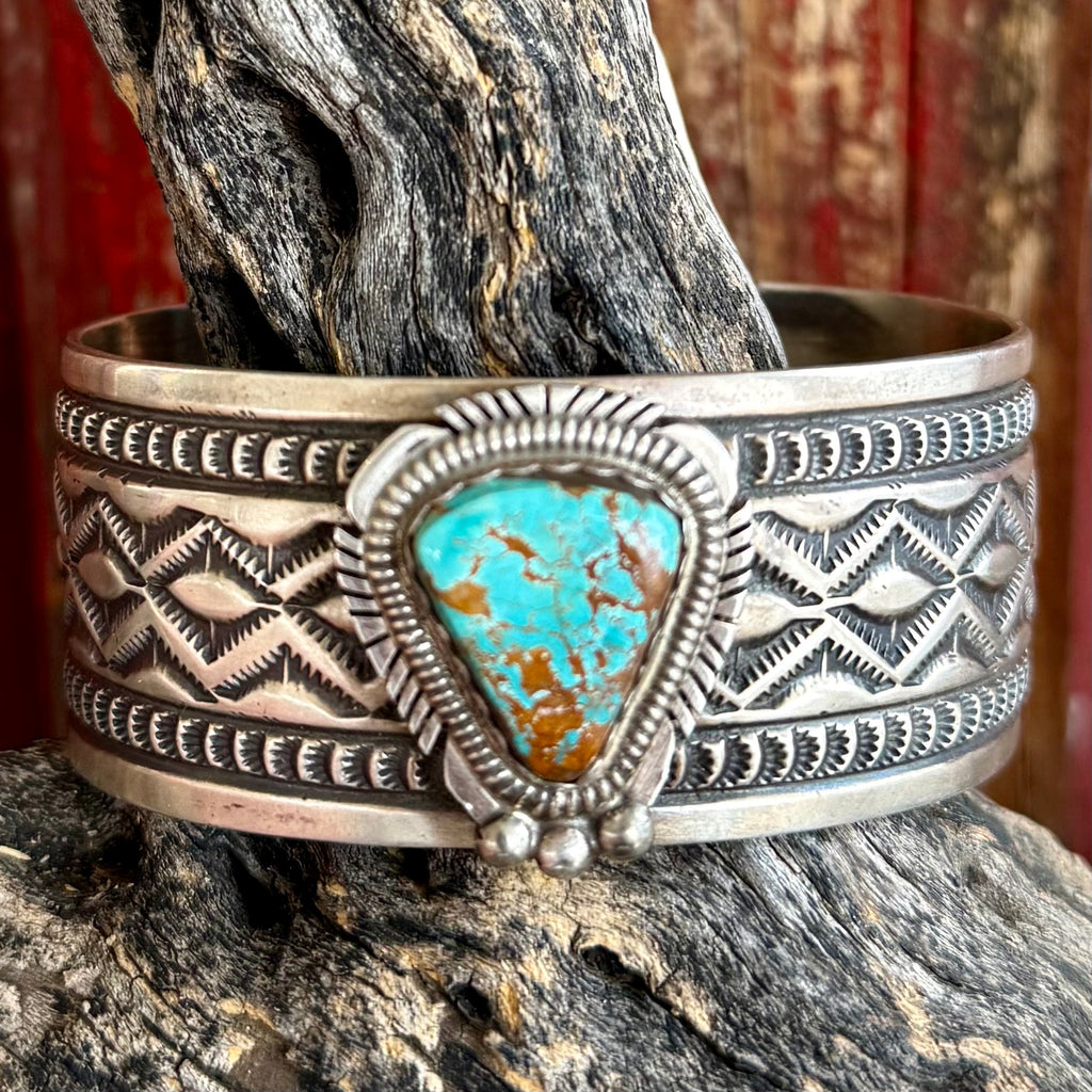 Nizhoni Traders bracelet turquoise sterling silver cuff bracelet in silver, handcrafted sterling silver cuff by Navajo artisan Leonard Maloney, with hand-stamped Aztec-inspired geometric patterns across a wide cuff - NZCUFFTHK. Available at Blair's Western Wear, Marble Falls, TX.