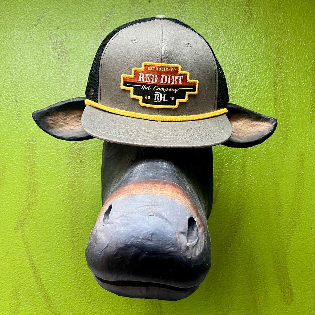 Red Dirt Hat Company Mesh Cap in Gray/Black/Yellow, with a bold Aztec-style logo patch on the front, and breathable black mesh backing for ventilation - RDHC267. Available at Blair's Western Wear, Marble Falls, TX.