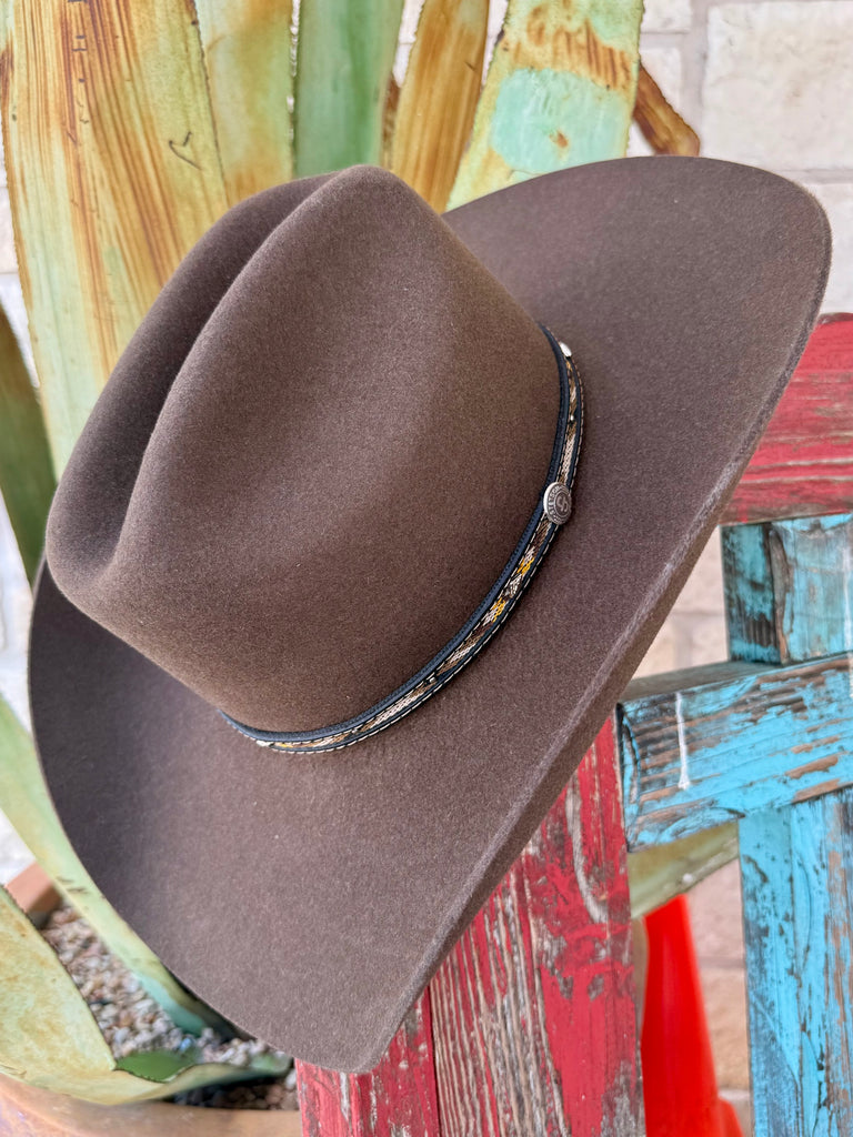 Men’s Resistol Whitmore 4X cowboy hat in oak brown, crafted from wool felt for durability, with a 4 1/4" brim for sun protection, and finished with a woven hatband featuring silver-tone concho detail – SBWTMR7242. Available at Blair's Western Wear, Marble Falls, TX.