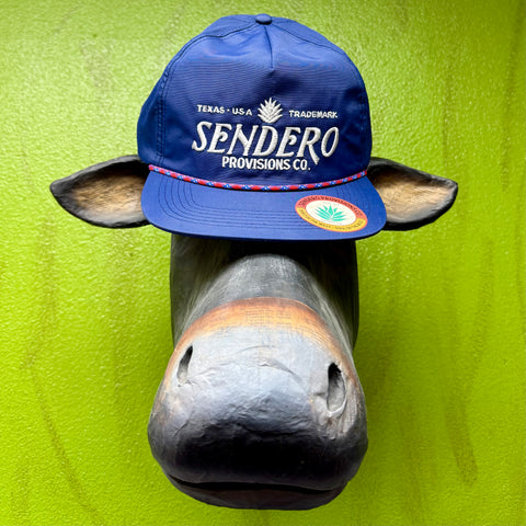 Men’s Sendero Provisions Co. blue logo cap in structured flat bill style, embroidered front logo for bold brand visibility, with braided rope accent across the crown - LOGO Navy. Available at Blair's Western Wear, Marble Falls, TX.