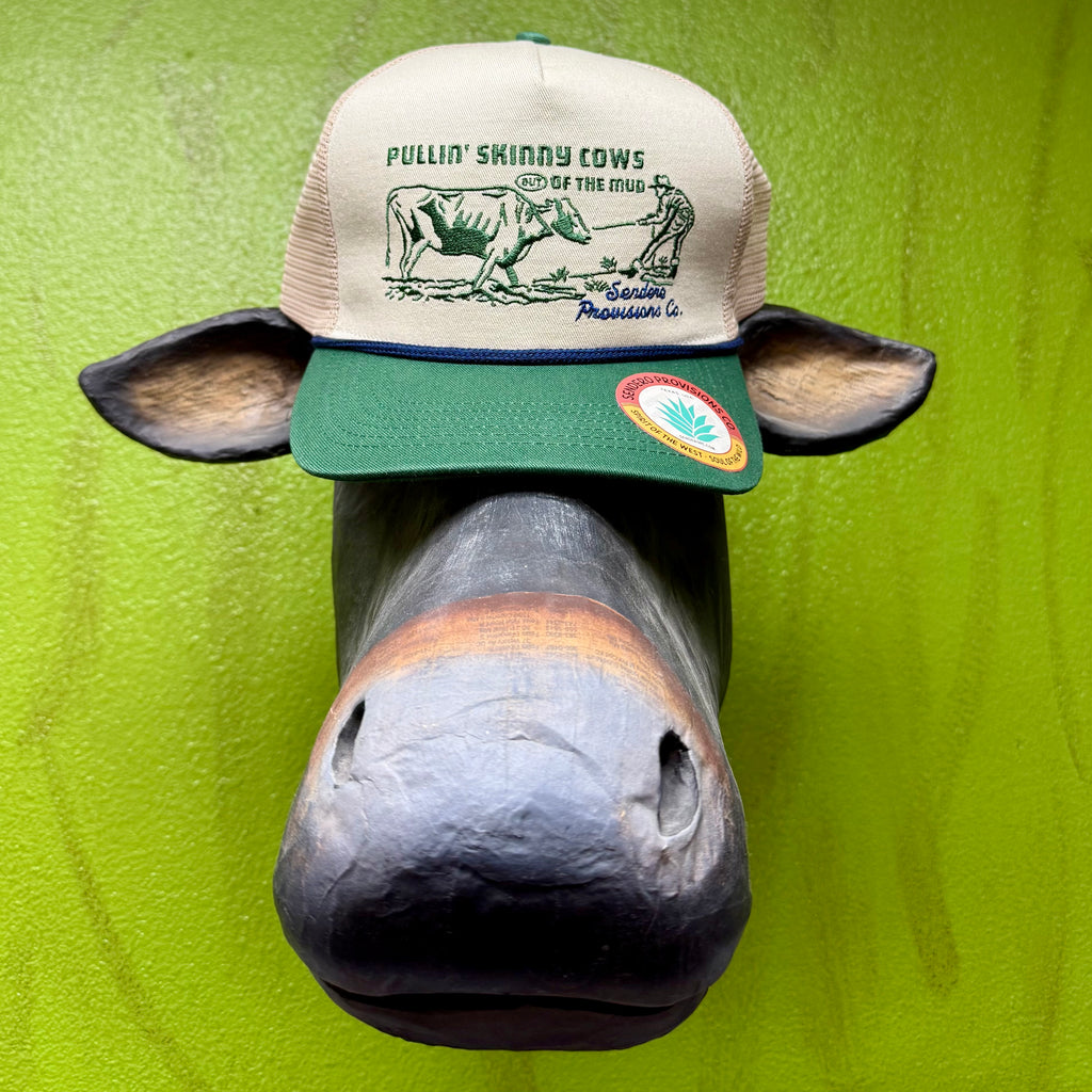 Sendero Provisions Co. trucker hat cream/green Pullin’ Skinny Cows design, with breathable mesh back, and adjustable snapback closure - SKINNY COWS. Available at Blair's Western Wear, Marble Falls, TX.