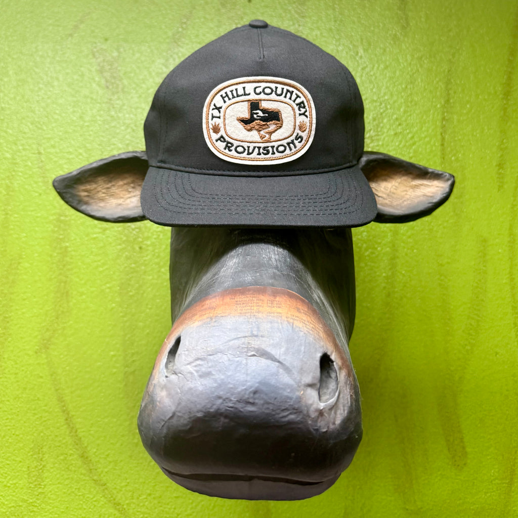 TX Hill Country Provisions Patch Hat in Black/Tan, features structured crown for a crisp shape, with adjustable snapback for a secure fit – HILL CNTRY BUCKLE. Available at Blair's Western Wear, Marble Falls, TX.