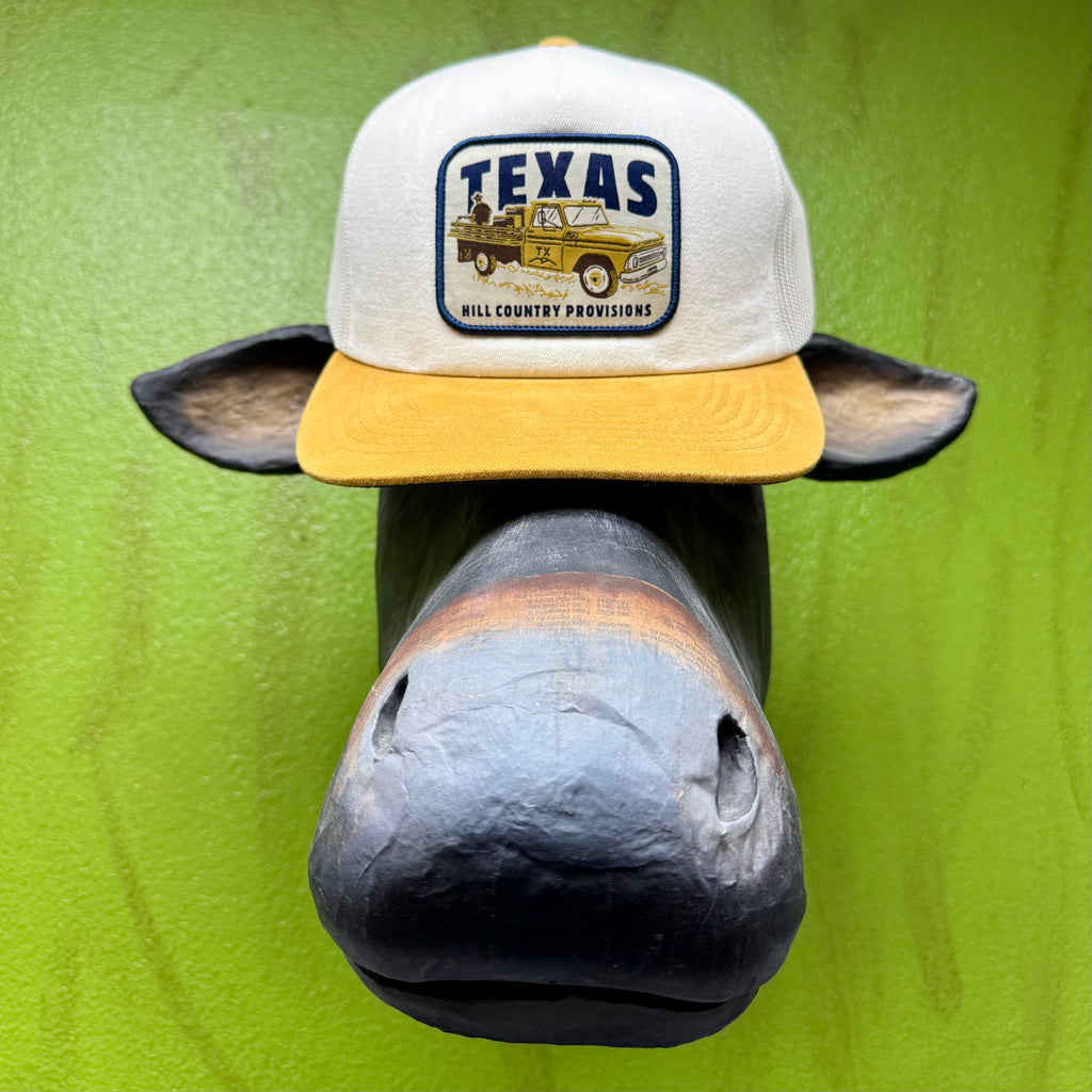 Texas Hill Country Provisions cap, trucker-style gold and white Pasture Party Cedar Chopper, featuring a structured wide-rib twill front and breathable mesh back with an adjustable snapback — PASTURE. Available at Blair's Western Wear, Marble Falls, TX.