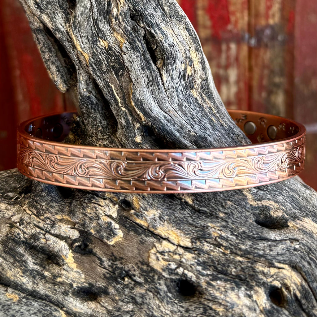 Western copper cuff bracelet in engraved scroll design, crafted from solid copper that develops natural patina over time, with detailed western scroll engraving and geometric stamped border - BC6431. Available at Blair's Western Wear, Marble Falls, TX.